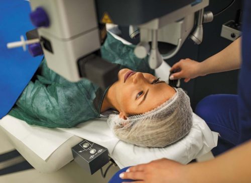 Patient lying on an operating table during an eye surgery procedure.